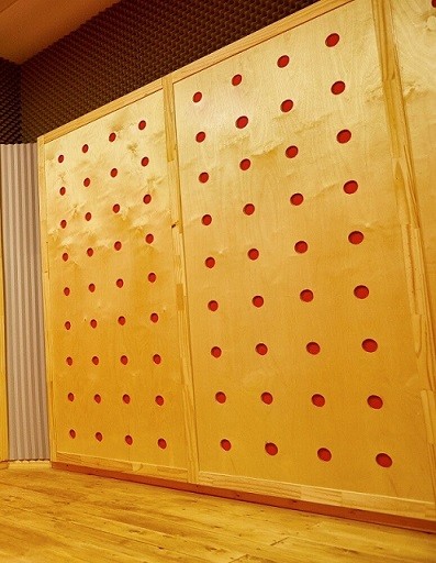 קיר סופג לחדר מוסיקה -לוחות עץ מחוררים ומאחור ,האדום-חומר סופג  באדיבות ליאור מור חדרים אקוסטיים .